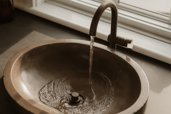 Water flowing into bronze sink basin